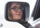Jim Thorpe graduate, Kaitlyn DeMarco, is reflected in the side-view mirror of her Jeep as she watches the graduation ceremony on the big screen at Pocono Raceway.